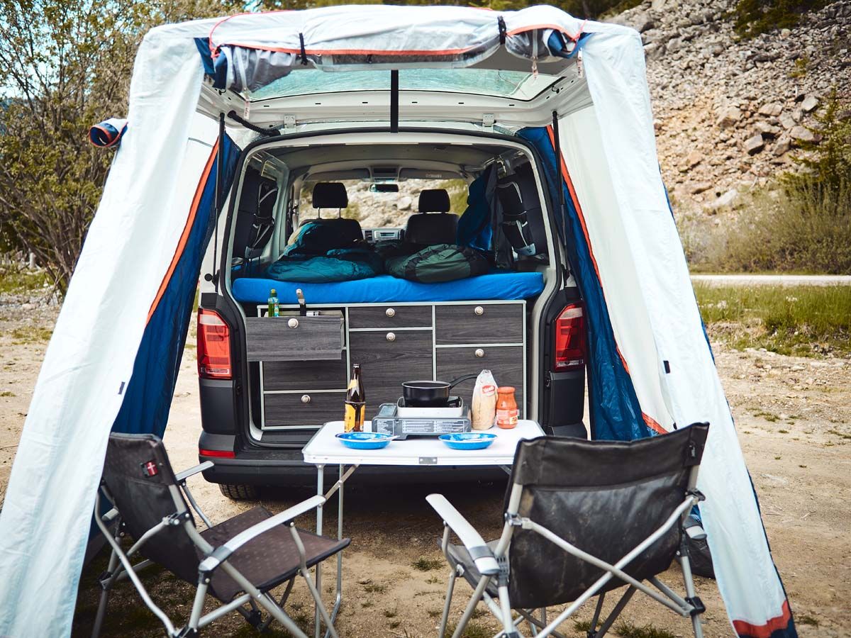 Ecocamper - kochen mit dem mobilen Gaskocher auf dem Tisch unter dem Heckzelt