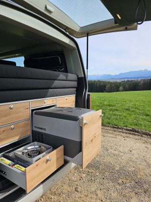 Heckküche mit Gasofen, Kühlschrank, Waschbecken und viel Stauraum. Gekocht werden kann mit dem 2. Kocher auch im Innenraum.