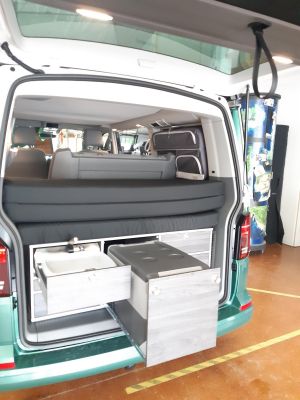 Heckküche mit Gasofen, Kühlschrank, Waschbecken und viel Stauraum. Gekocht werden kann mit dem 2. Kocher auch im Innenraum.